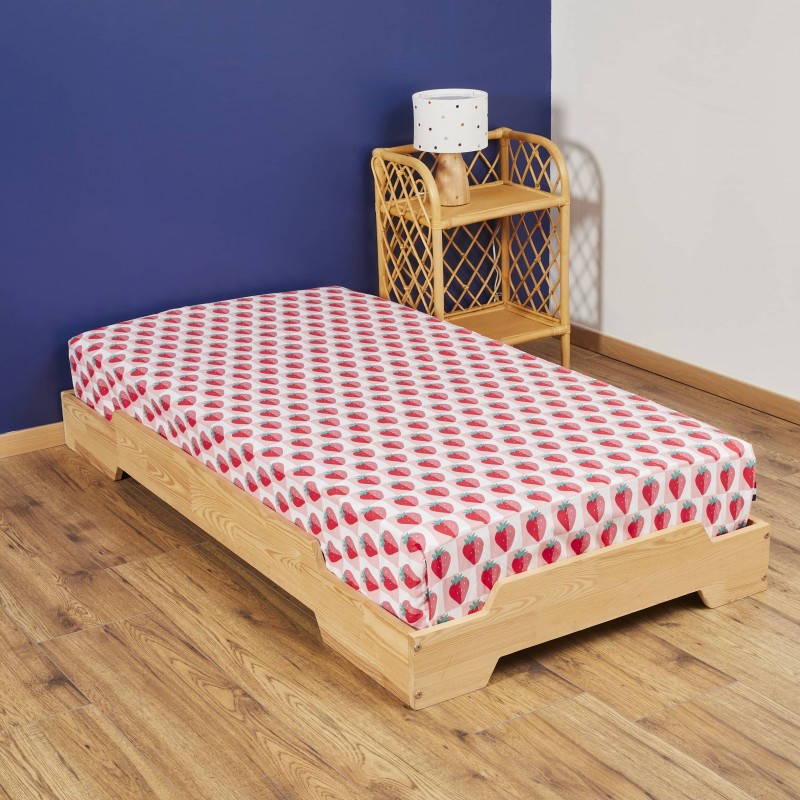 Drap housse motif fraises sur lit en bois