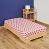 Drap housse motif fraises sur lit en bois